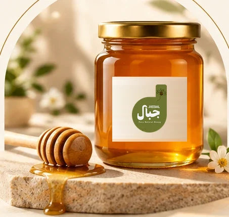 A JIBAL honey jar beside a wooden honey dipper