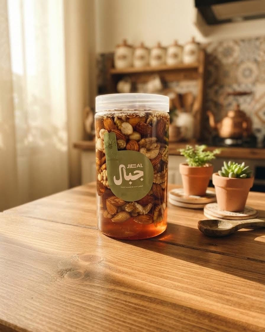 علبة مكسرات بالعسل من جِبال على طاولة خشبية بجوار نباتات صغيرة في أصص