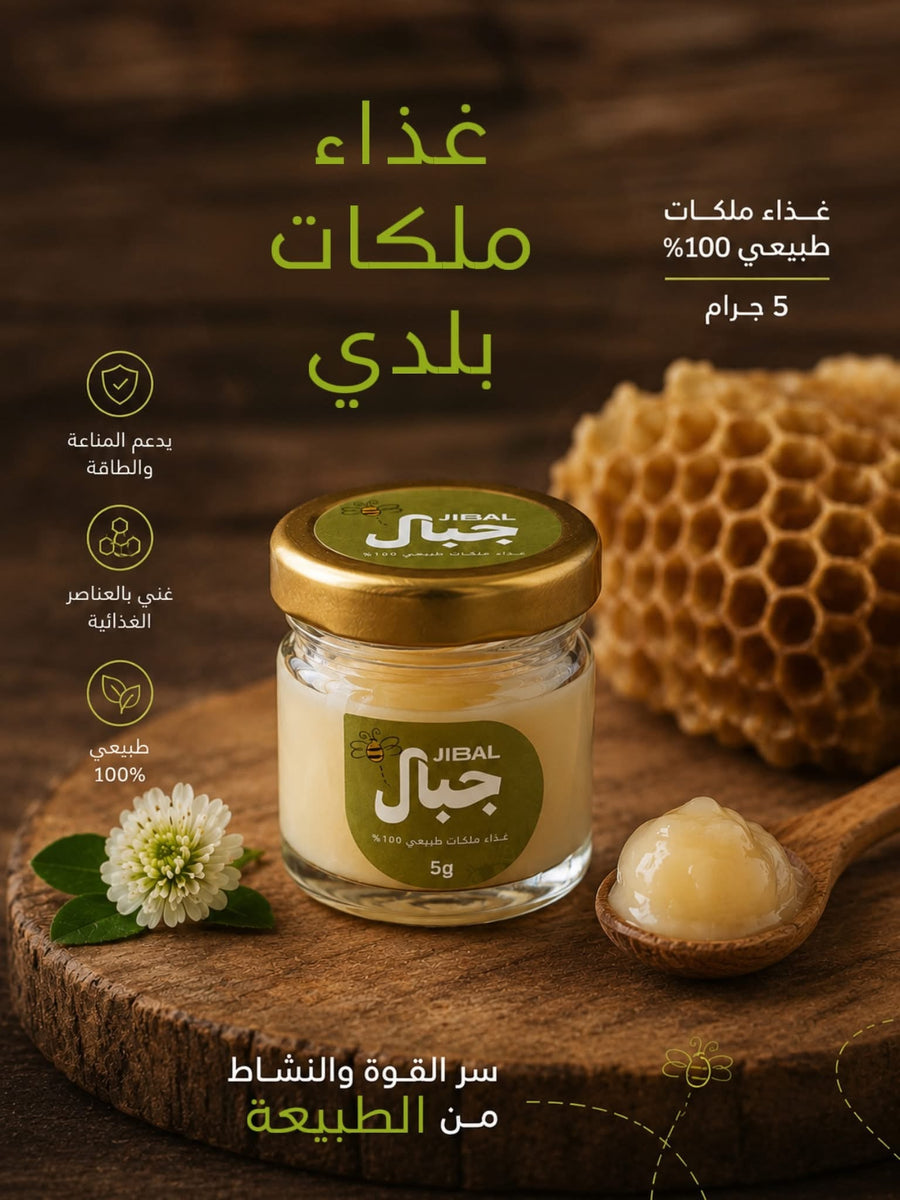 عبوة زجاجية صغيرة 5 جرام من غذاء الملكات البلدي من جِبال بغطاء ذهبي، بجوار ملعقة خشبية وقرص شمع عسل